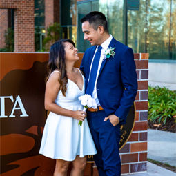 Beaming newlyweds share a tender moment outside City Hall, their love shining brightly amidst the urban charm of the cityscape behind them.