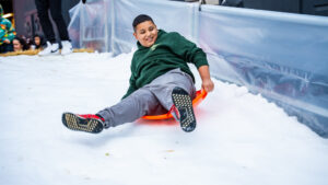 Kid sledding down snow