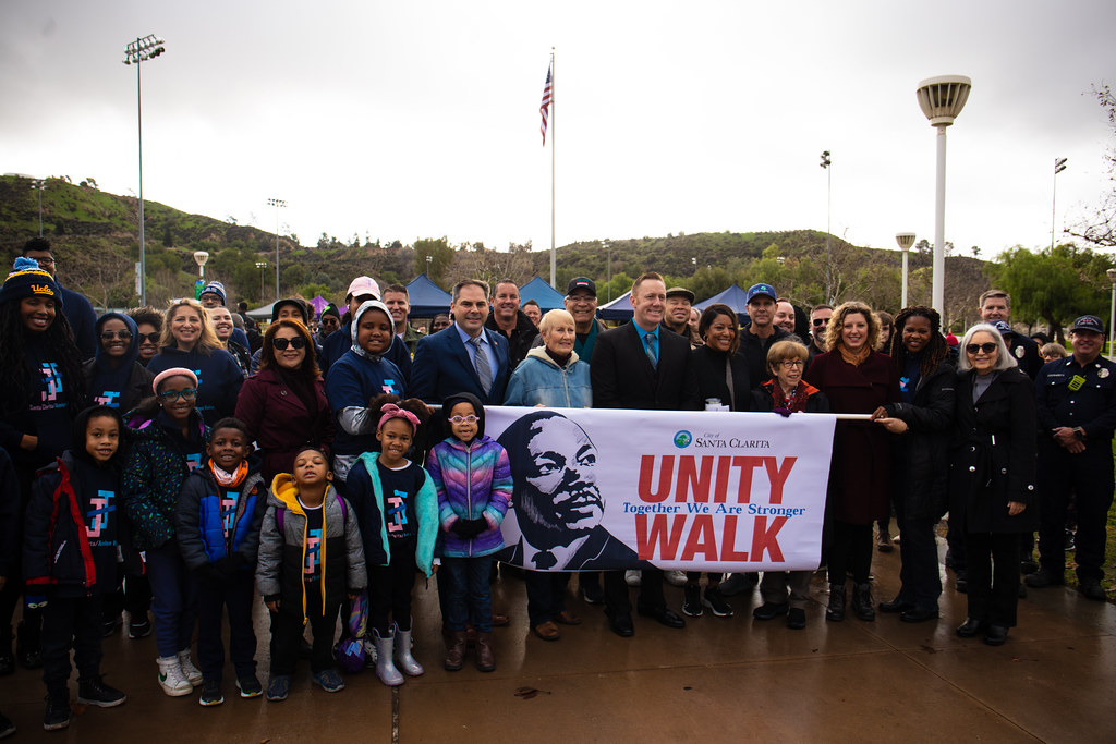 Walking group standing in front of MLK Unity Walk Banner