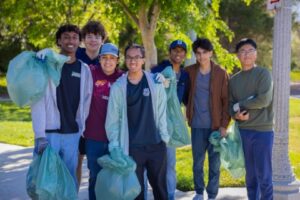 Group standing with trash bags cleaning up the neighborhood
