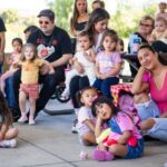 Families sitting outside listening to a book