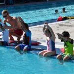 Lifeguard teaching children to swim