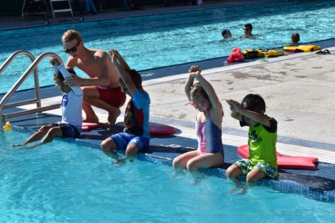 Lifeguard teaching children to swim