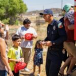 Families listening to a fire fighter and exploring a fire truck