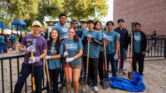 Volunteers standing and smiling with shovels