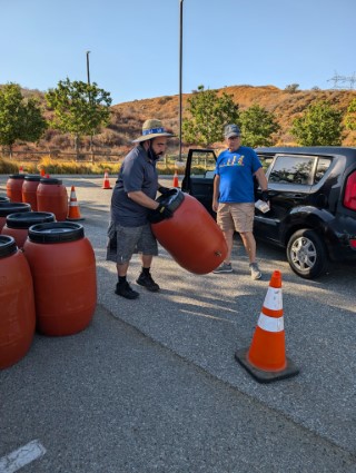 Resident picking up his rain barrel