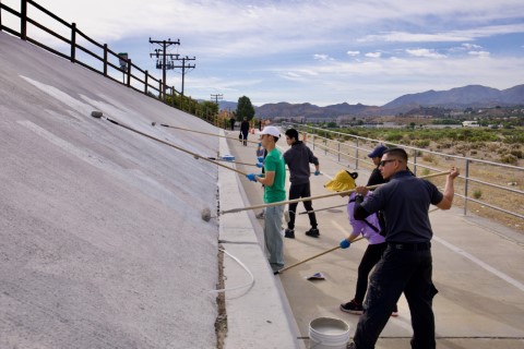 Volunteers painting over graffiti on walls