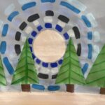 Pine trees in front of a grey and blue landscape