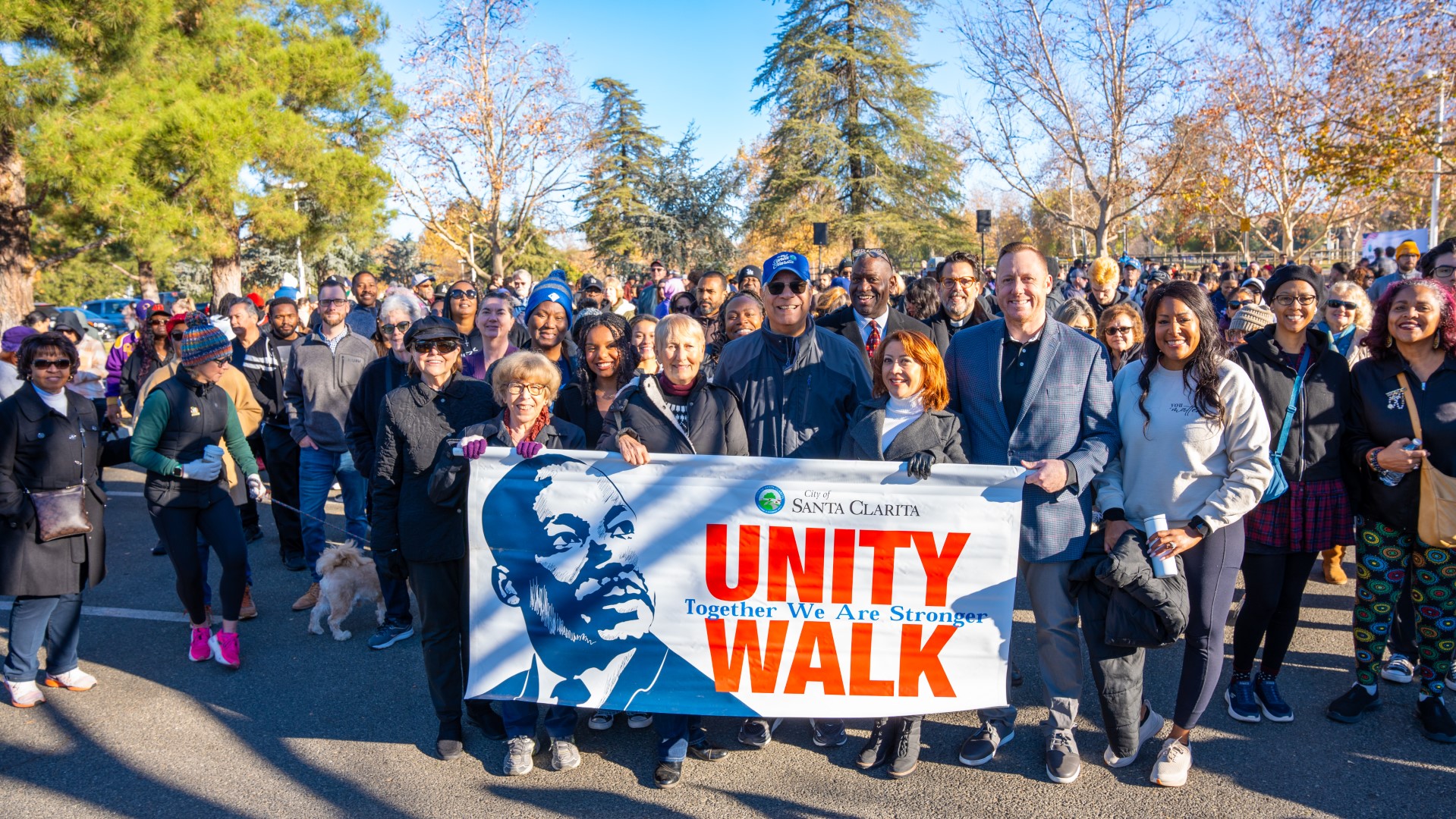 Participants walking in the annual MLK, Jr. Day Unity Walk holding a banner with Dr. Martin Luther King, Jr. and the words "Unity Walk."