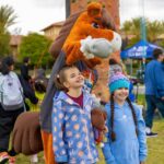 Sammy Clarita - the City of Santa Clarita's mascot, a horse, standing with two children at FestAbility.
