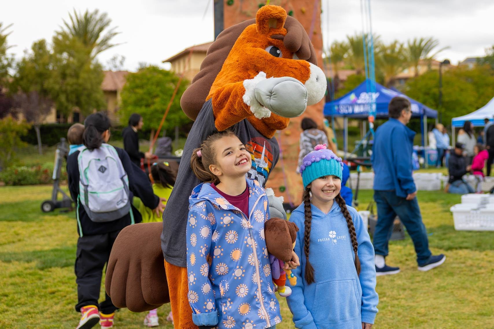 Sammy Clarita - the City of Santa Clarita's mascot, a horse, standing with two children at FestAbility.