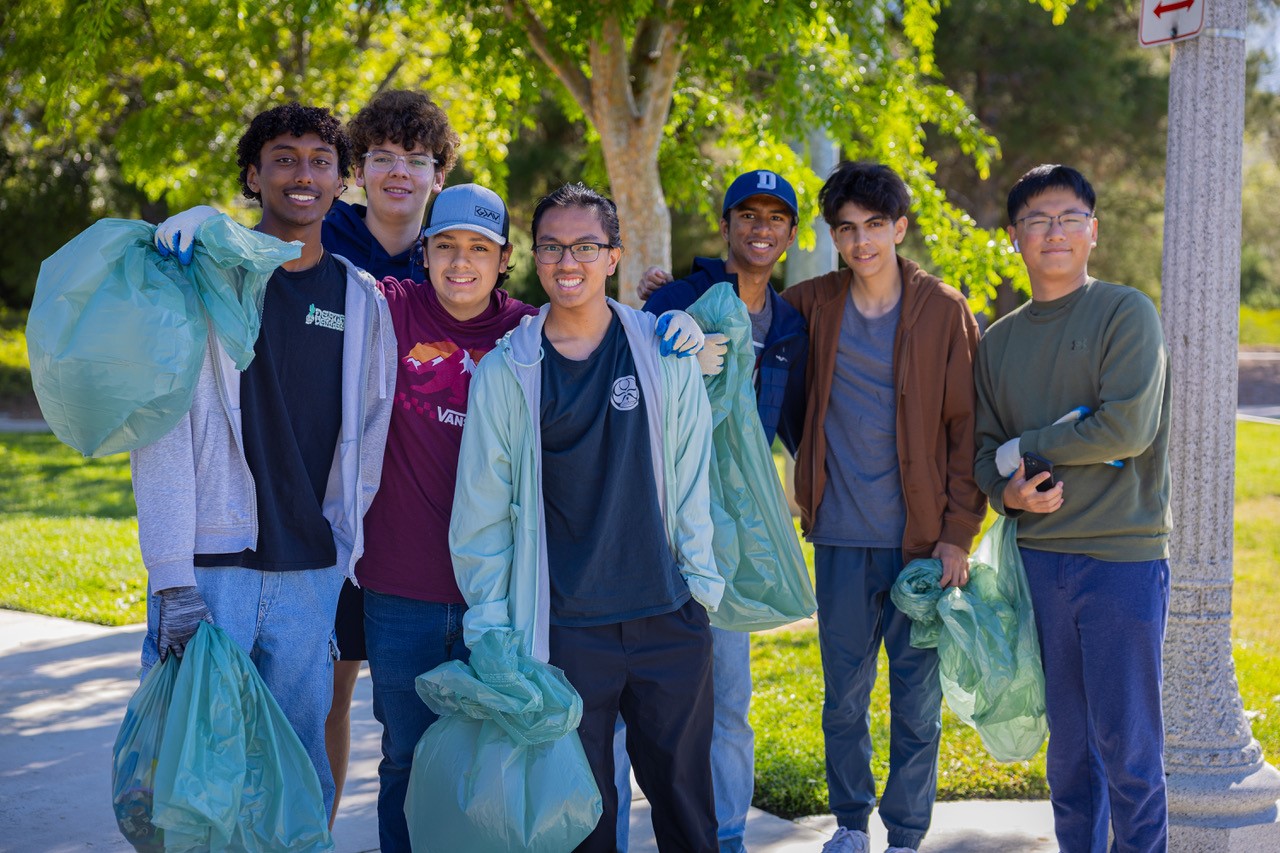 Volunteers holding trash bags as they participate in Neighborhood Cleanup.