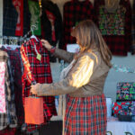 Light Up Main Street attendee looking at clothes in Makers Marketplace booth.