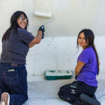 Community Beautification Day - Volunteers helping paint walls white.